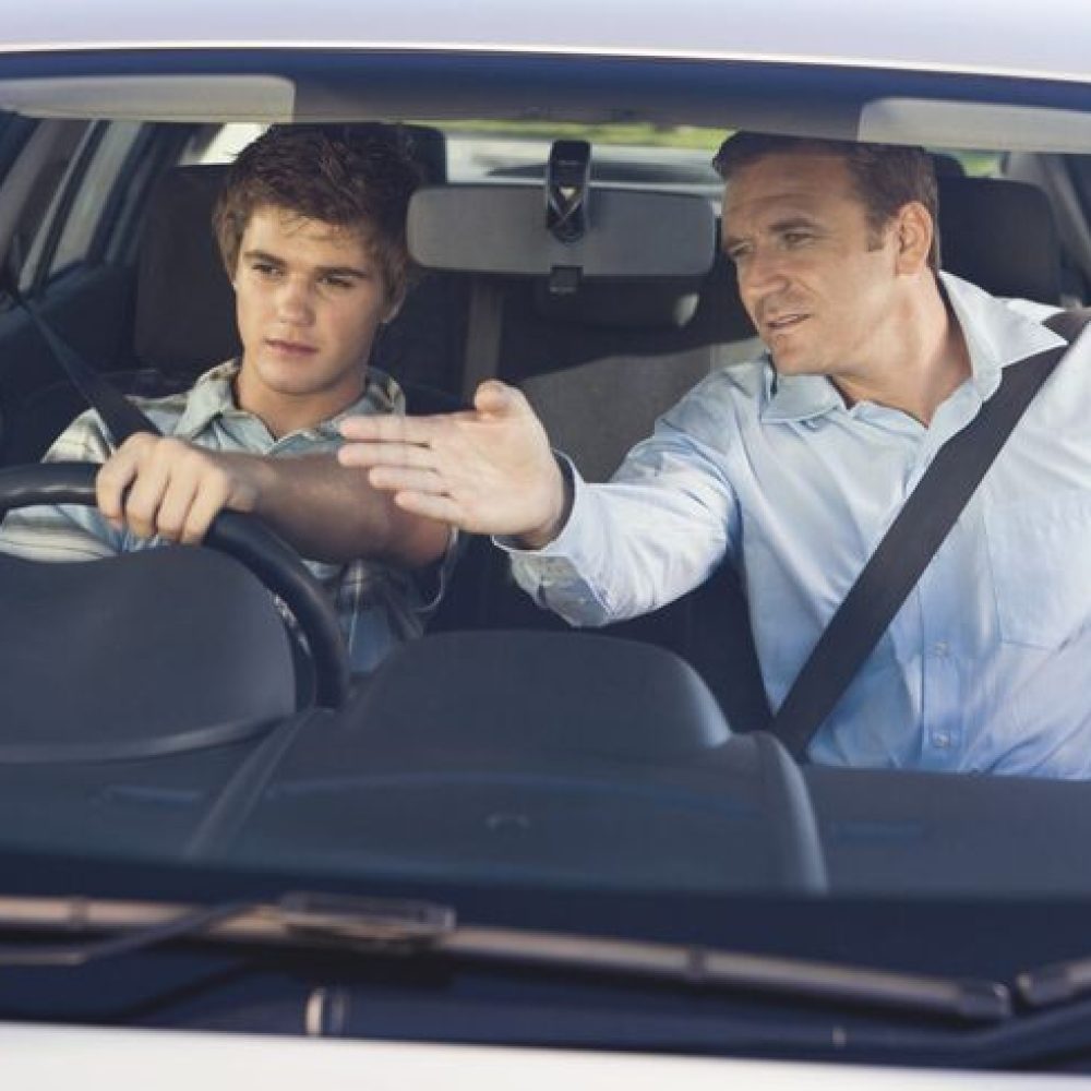 Father instructing son driving